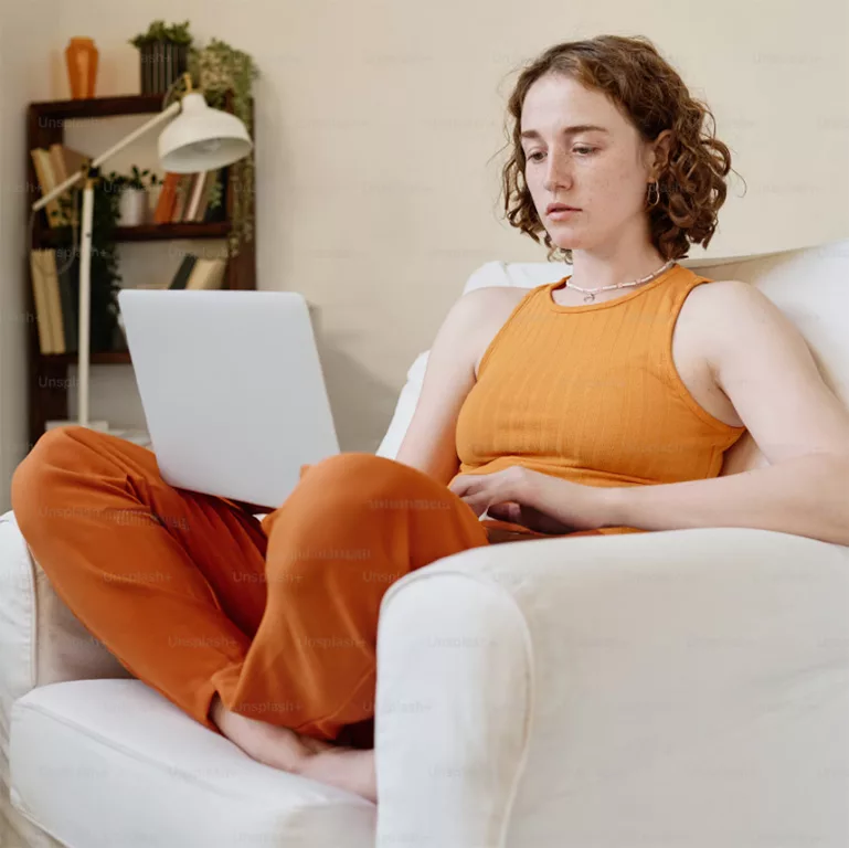 Image of Girl having online therapy sitting on sofa